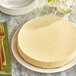 A round white cake with a slice cut out on a white plate.