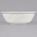 A CAC white porcelain bowl with a wavy design on a white surface.