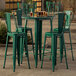 A Lancaster Table & Seating emerald green table with chairs on an outdoor patio.