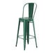 An emerald green metal barstool with a backrest.