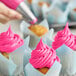 A cupcake with Rich's Allen Bright Pink Buttrcreme icing.