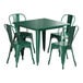 A Lancaster Table & Seating emerald green metal table with four chairs around it.