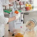 A man using an AvaMix continuous feed food processor to peel a bell pepper.