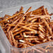 A white plastic container of Tom Sturgis Thin Stix Pretzels on a counter.