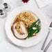 A CAC ivory scalloped edge china plate with meat, rice, and green beans on it with a silver fork.