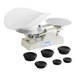A baker's dough scale with a scoop and several round weights.