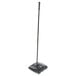 A black Rubbermaid Executive Series floor sweeper with a long handle.