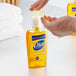 A person pouring Dial Professional Gold liquid hand soap into a soap dispenser.