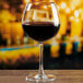 An Anchor Hocking Matera burgundy wine glass filled with red wine on a table.