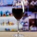 An Anchor Hocking Sondria wine glass filled with red wine on a table.