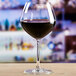 An Anchor Hocking Sondria burgundy wine glass filled with red wine on a table.