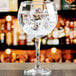 A close up of an Anchor Hocking Cienna Gin and Tonic glass filled with water and ice cubes.