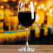 An Anchor Hocking Matera wine glass filled with red wine on a table.