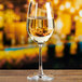 An Anchor Hocking Matera wine glass filled with white wine on a table.