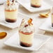 Three small dessert cups topped with Mona Lisa marbled chocolate shavings on a white plate.
