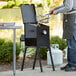 A man using a Backyard Pro fryer basket to cook food on a grill.