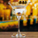 An Anchor Hocking martini glass filled with a martini and olives.