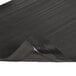 A close-up of a black Notrax anti-fatigue mat with a black rubber edge.