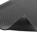 A black rubber Notrax anti-fatigue mat with circles on it.
