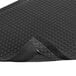 A black rubber Notrax Diamond-Tuff anti-fatigue mat with a corner cut off.
