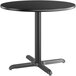 A black round Lancaster Table & Seating table top with a metal base.