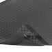 A black rubber Notrax Dura Trax Grande anti-fatigue mat with a corner curled up.