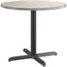 A Lancaster Table & Seating round table with white and slate grey surfaces on a black base.