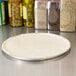 A white pizza dough on an American Metalcraft aluminum pizza pan.