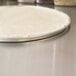 A pizza dough on an American Metalcraft aluminum pizza pan.