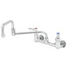 A chrome T&S wall mounted faucet with double-jointed swing spout and lever handles.