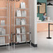 A woman standing at a Metro stainless steel takeout station with heated and chrome shelves holding a paper.