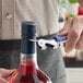 A person using an Acopa Waiter's Corkscrew to open a bottle of wine.