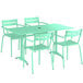 A Lancaster Table & Seating seafoam green table with umbrella hole and 4 arm chairs on an outdoor patio.