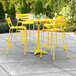 A yellow table and chairs on an outdoor patio.