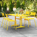 A yellow table and chairs on a patio.