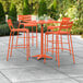An orange table with chairs on a patio.