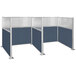 Three Versare Hush Panel metal cubicles with blue fabric and windows.