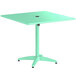 A seafoam green Lancaster Table & Seating outdoor table with a black round top.