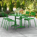 A green Lancaster Table & Seating outdoor table with chairs on a patio.