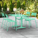 A seafoam green Lancaster Table and Seating outdoor table with four chairs.