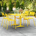 A yellow table and chairs on a patio.