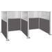 A Versare charcoal grey H/W-shape double cubicle with window and glass panels.