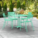 A Lancaster Table & Seating seafoam green table with 4 chairs on a patio.