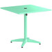 A seafoam green Lancaster Table & Seating outdoor table with a black round top.