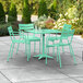 A Lancaster Table & Seating outdoor patio table in seafoam green with 4 arm chairs.