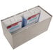 A metal Carlisle insulated dispenser with 2 white containers inside and blue ice packs.