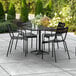 A black Lancaster Table & Seating outdoor table with four arm chairs.