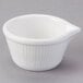 A Tuxton white china ramekin with a spout and handle.