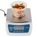 A plastic container of pasta on an Edlund digital portion scale.