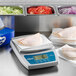 An Edlund digital portion scale on a counter with food on it.